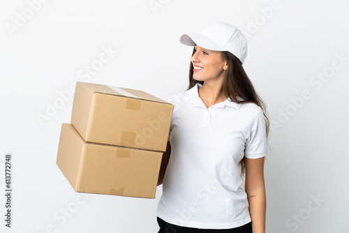 Young delivery woman over isolated white background looking side © luismolinero