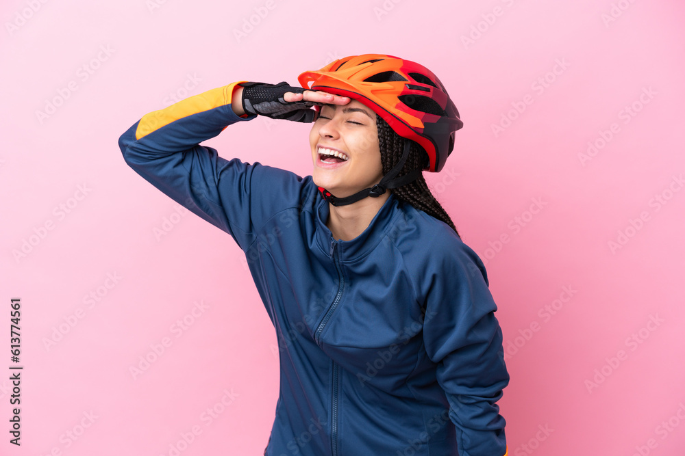 Teenager cyclist girl isolated on pink background smiling a lot - obrazy, fototapety, plakaty 