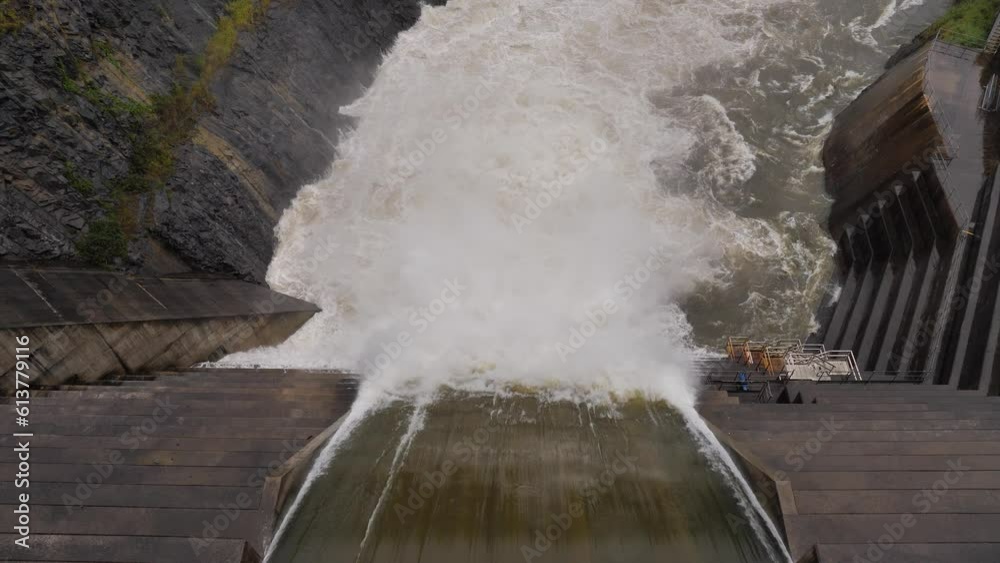 Top down handheld shot of Hinze Dam overflow under heavy rain during La