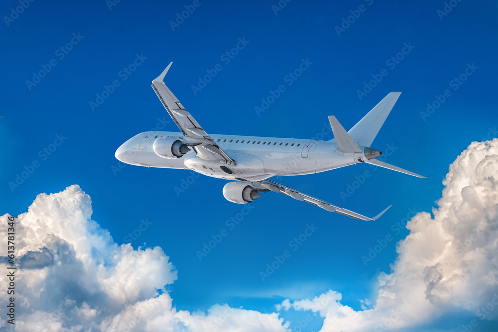 Obraz premium White passenger jet plane fly in the air above scenic clouds