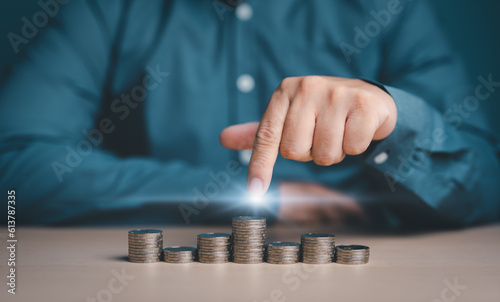 Investor, Trader, Analyst, Funder, Stock marketer, or Businessman pointing on stacked coins for interest rating investment, Financial profit, and world economic growth and marketing control concept.