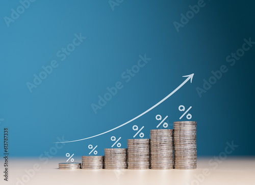 Financial interest rates hike, dividends and mortgage rates increase. Wooden blocks with percentage growth bar and arrow pointing up icon on stacked coins. Inflation, sale price and tax rise concept.