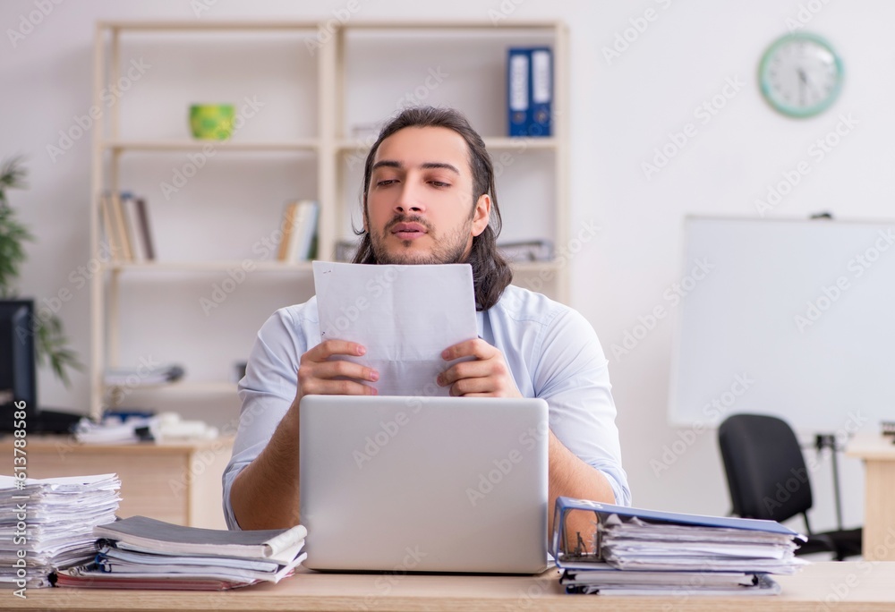 Young male employee unhappy with excessive work Young male employee unhappy with excessive work