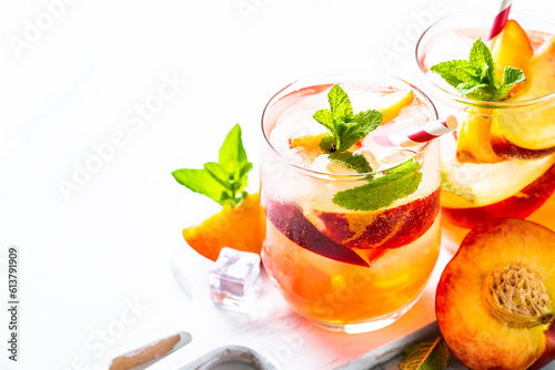 Peach tea, iced cold drink with fresh fruits, ice and mint. Close up with space for text.