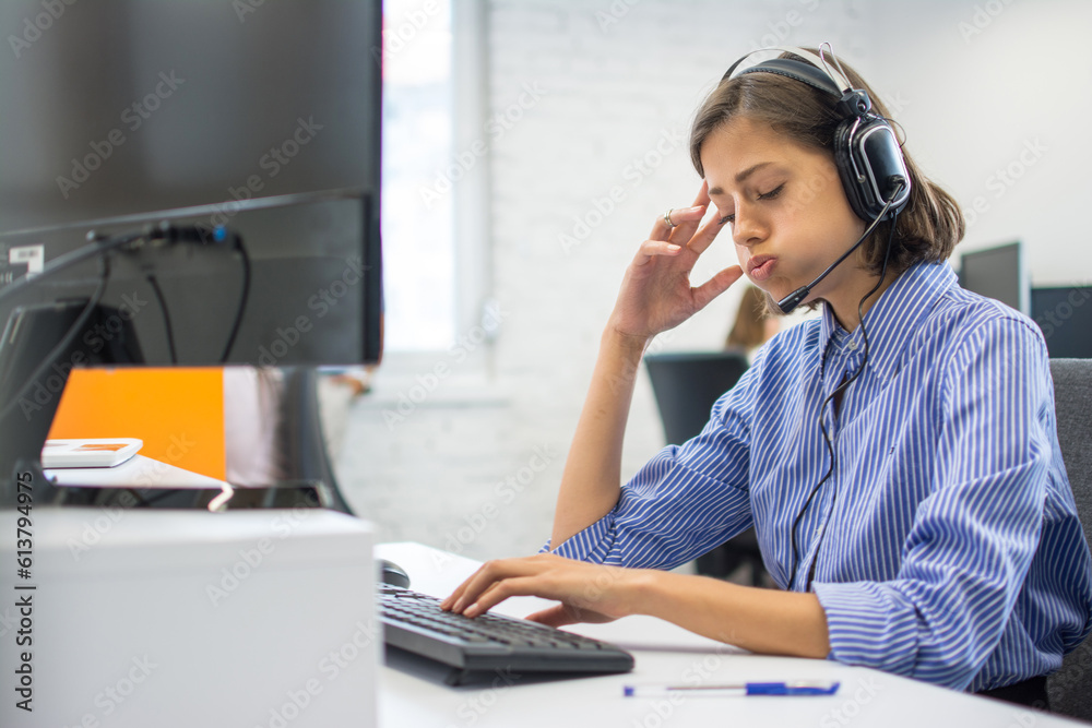 Tired call center operator woman at workplace in office. Tired call center operator woman at workplace in office.