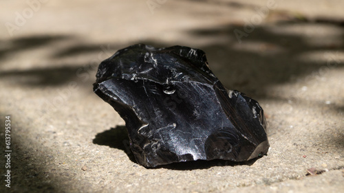 A piece of obsidian. Obsidian in sunlight. Black obsidian photo