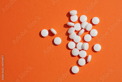 Tablets and caplets pills pharmaceutical dosage form on orange background. Pharmacy and health topics background. Top view, copy space