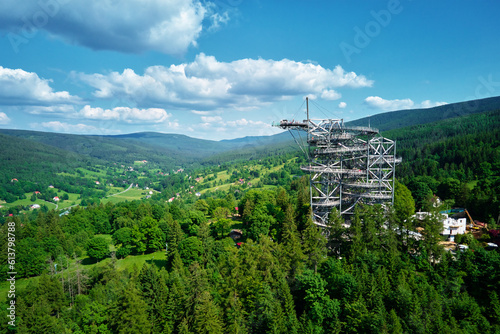 Fototapeta Naklejka Na Ścianę i Meble -  Sky Walk observation tower in Sweradow Zdroj, Poland. Tourist attraction in montains, aerial view. Panoramic view of nature landscape with green forest