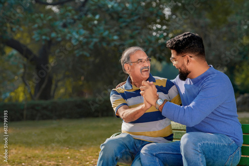 Old indian father with his young son spending time at park. © Niks Ads