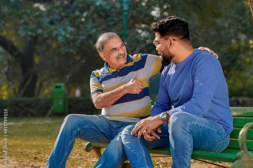 Old indian father with his young son spending time at park.