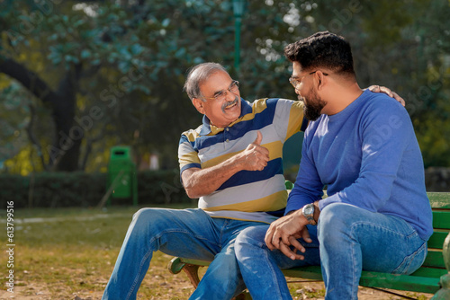 Old indian father with his young son spending time at park. © Niks Ads