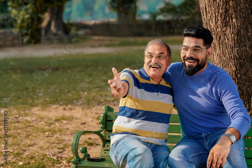 Old indian father with his young son spending time at park.