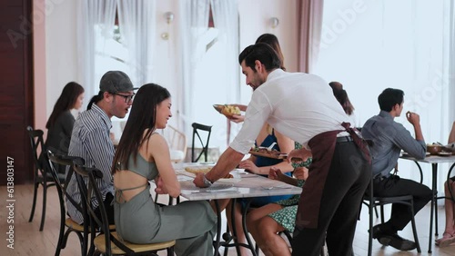 Professional waiter man and woman serving food together for group of guest at table in banquet, Service of Food and Restaurant party concept