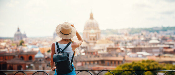 Young attractive smiling girl tourist exploring new city at summer