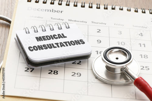medical consultation in an office notebook on a calendar next to a stethoscope. photo