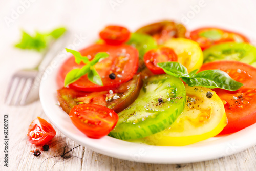 slices tomatoes salad with basil leaves