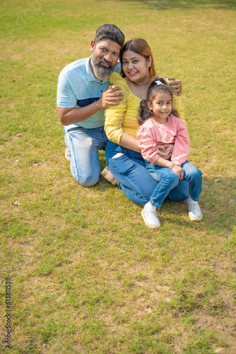 Happy indian couple with his little girl at garden.