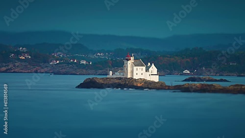 Gronningen lighthouse stands on the tiny rocky islet on the coast near Kristiansand, Norway. Tilt-shift video. photo