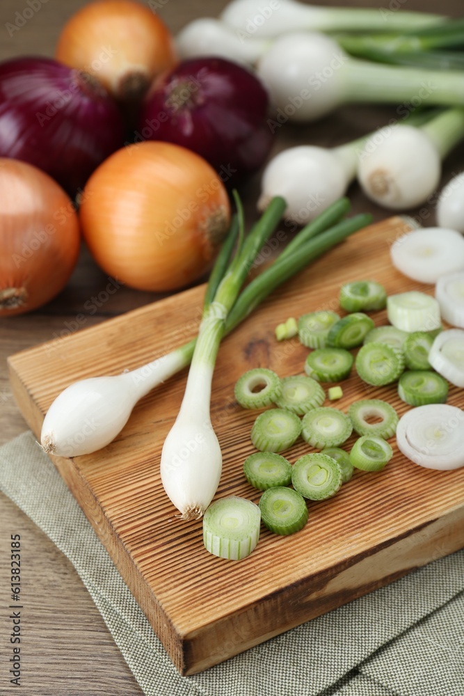 Different kinds of onions on wooden table, closeup Different kinds of onions on wooden table, closeup