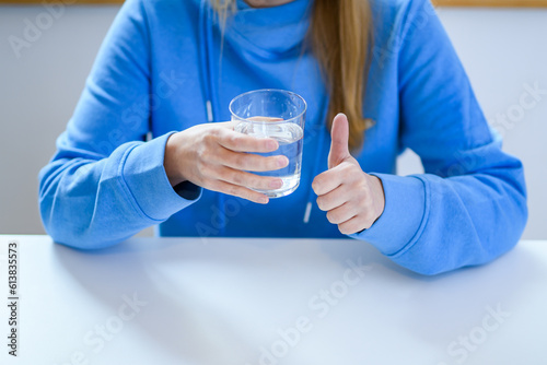 Pić wodę, kobieta trzymająca w dłoni szklankę pełną niegazowanej wody mineralnej 