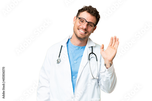 Brazilian doctor man over isolated chroma key background saluting with hand with happy expression