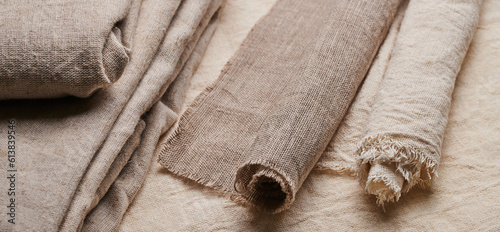 Linen in different textures and colors. Natural fabrics from organic flax and cotton in rolls, homespun textile handmade. Burlap and canvas for eco, rustic, boho, hygge decor .