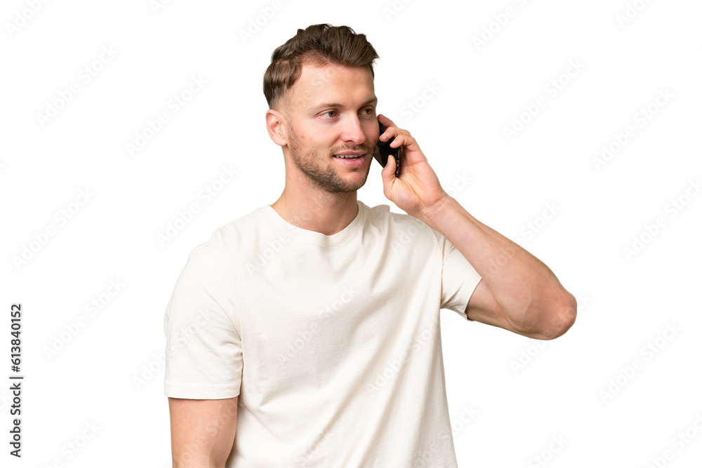 Young blonde caucasian man over isolated background keeping a conversation with the mobile phone Young blonde caucasian man over isolated background keeping a conversation with the mobile phone