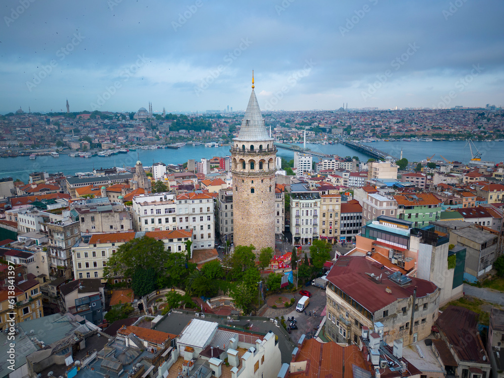 Galata Tower aerial view with morning twilight with Golden Horn at back in Beyoglu in historic city of Istanbul, Turkey. Historic Areas of Istanbul is a UNESCO World Heritage Site since 1985. 