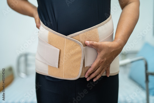 Photography Asian lady patient wearing back pain support belt for orthopedic lumbar with walker