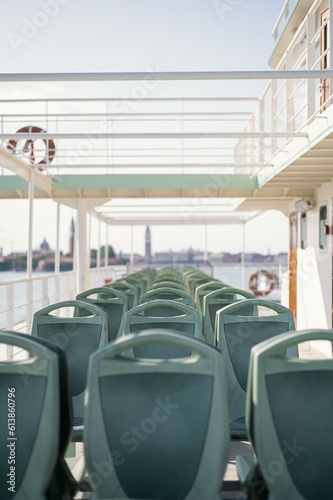 empty ferryboat seats in Venice Italy, in the background it can be seen the bell towers of Saint Marks Square and saint Giorgio Maggiore's Island