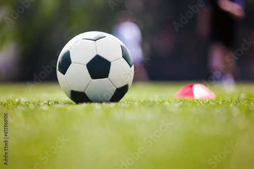 Soccer, training and children on sports field. Football equipment at sports grass pitch. Soccer ball and training cone marker on the pitch. Children on sports practice