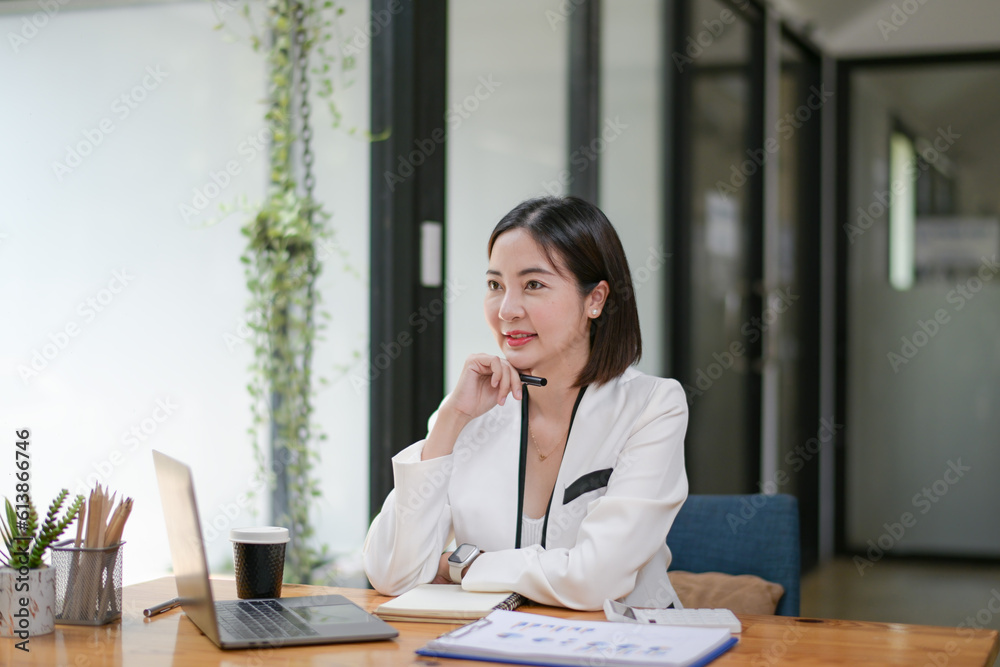 Happy smiling business woman working with laptop computer with paperwork at desk in a modern office, business finance technology concept. Happy smiling business woman working with laptop computer with paperwork at desk in a modern office, business finance technology concept.