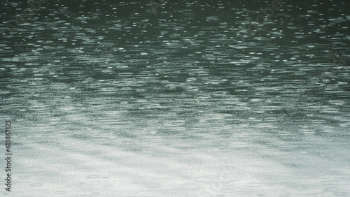 Raindrops on water surface. Raindrops falling on teal colored water. Minimal background.