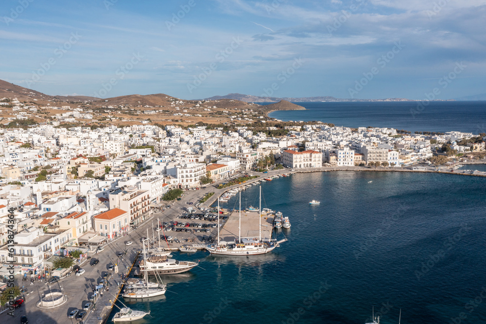 Greece Tinos island Hora town Cyclades. Aerial drone view of port moored ship, Aegean sea blue sky.