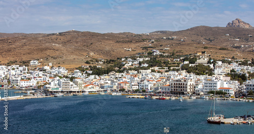 Greece Tinos island Cyclades. View from ship of Chora town cafe, building, port, sea, blue sky.