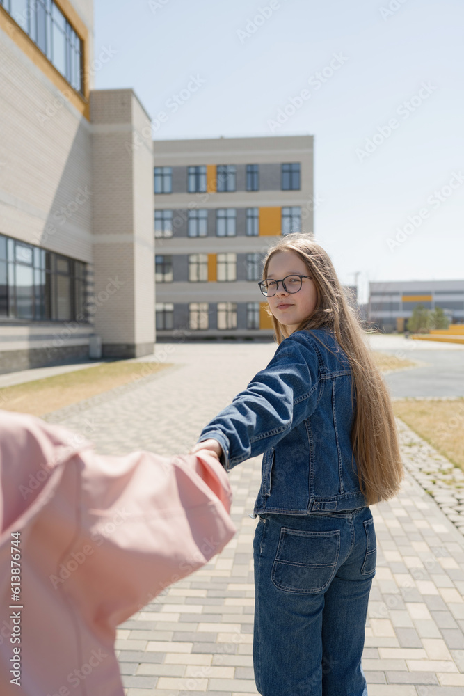 Girl holding hand of friend on pavement in city Girl holding hand of friend on pavement in city
