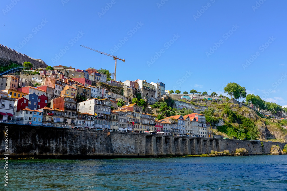 Porto, Portugal old town skyline from across the Douro River. Colorful facades of houses in the old district Cais da Ribeira