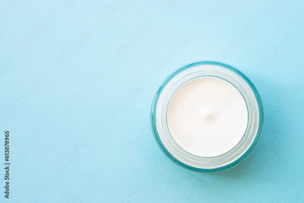 Natural cosmetic, cream jar with green leaves on blue. Flat lay with copy space. Natural cosmetic, cream jar with green leaves on blue. Flat lay with copy space.