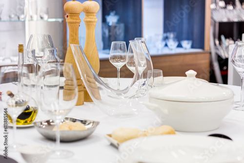 interior of a kitchen assortent shop / hotel or restaurant assortment shop / table set with wine glasses, plates and silverware © Bartek
