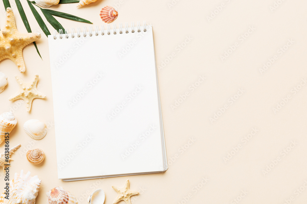 Blank writing book with summer beach accessories on background, copy space. Flat lay with copy space