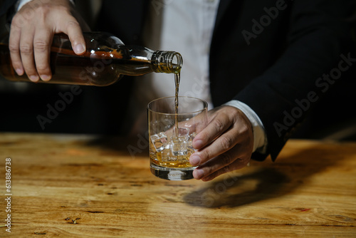 Barman pouring whiskey whiskey glass celebrate whiskey on a friendly party in restaurant