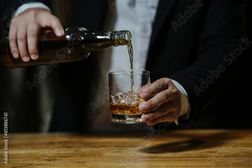 Businessman sitting Holding a Glass of Whiskey Drink Whiskey in the liquor store room