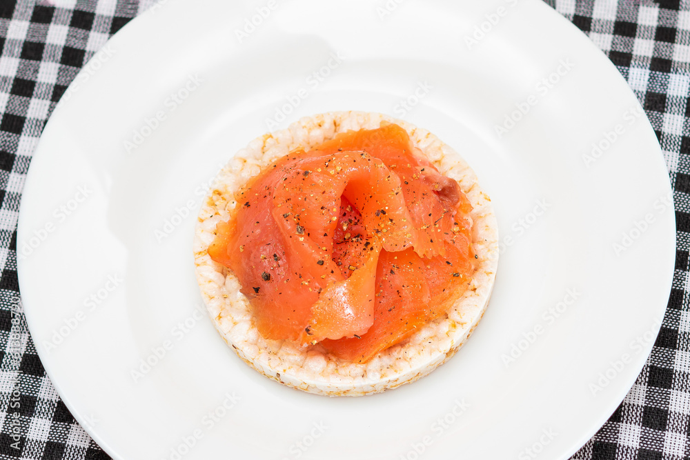 Tasty Rice Cake Sandwich with Fresh Salmon Slices on White Plate - Top View. Easy Breakfast and Diet Food. Crispbread with Red Fish. Healthy Dietary Snack Tasty Rice Cake Sandwich with Fresh Salmon Slices on White Plate - Top View. Easy Breakfast and Diet Food. Crispbread with Red Fish. Healthy Dietary Snack