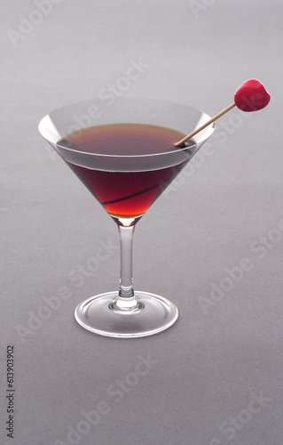 Verre a cocktail, liqueur rouge avec une cerise. (ID: 613903902)