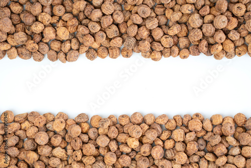 Top view of a of tigernuts on a white background with copy space in the middle