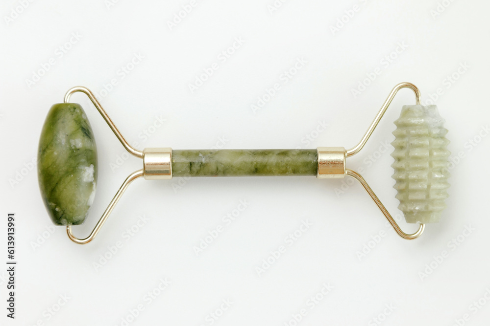 Obraz na płótnie Facial jade massage roller made of green quartz stone on white background. w salonie