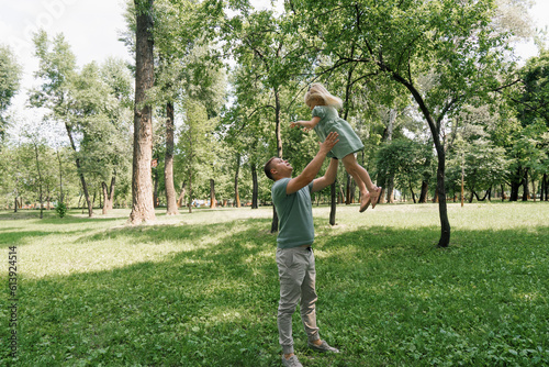 Dad plays with a child in the park throws his daughter in the sky Happy family Father's Day Family play with a child