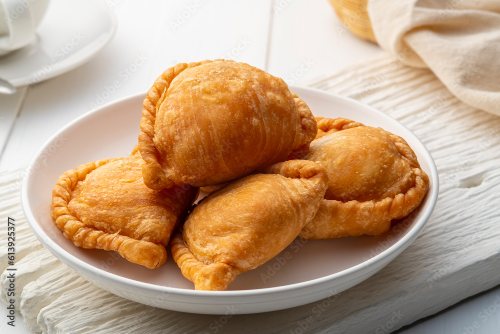 curry puff in white plate,fried curry dumpling (with meat or vegetable snuffing)