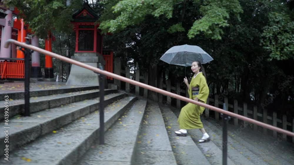 Elegant Japanese woman walking in the rain at dawn Elegant Japanese woman walking in the rain at dawn