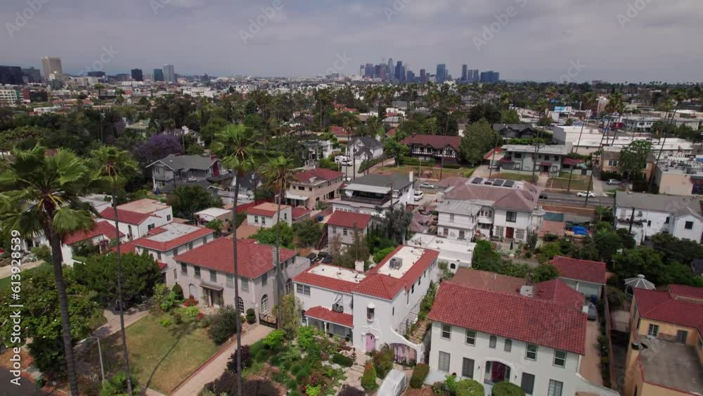 Drone aerial view of California large scale downtown district and business center of Los Angeles behind an upper class suburb and rich neighborhood with palm trees and streets Drone aerial view of California large scale downtown district and business center of Los Angeles behind an upper class suburb and rich neighborhood with palm trees and streets